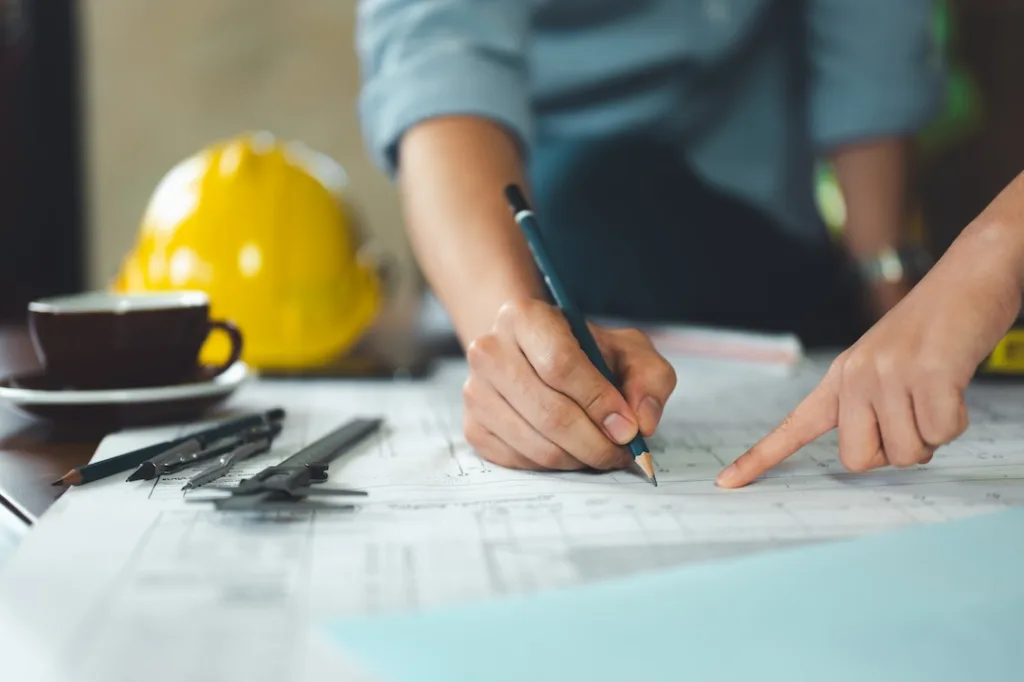architect, engineer, engineering, architecture, design, plan, plans, construction, Engineers and architects review technical blueprints together, marking details and coordinating design plans.